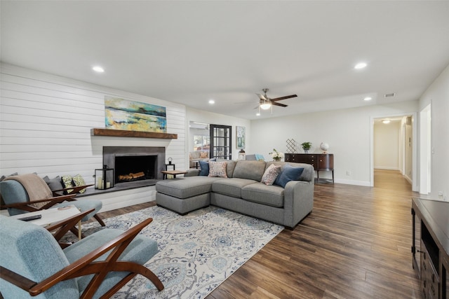 living room featuring dark wood-type flooring and ceiling fan