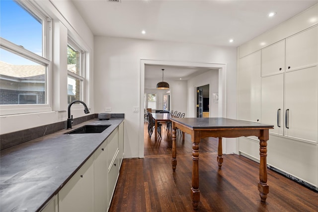 kitchen with sink, pendant lighting, white cabinetry, and dark hardwood / wood-style flooring