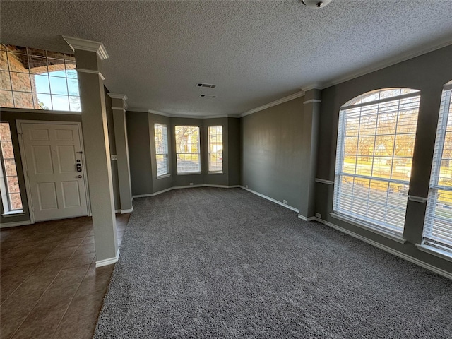 foyer entrance featuring dark carpet, a textured ceiling, and crown molding