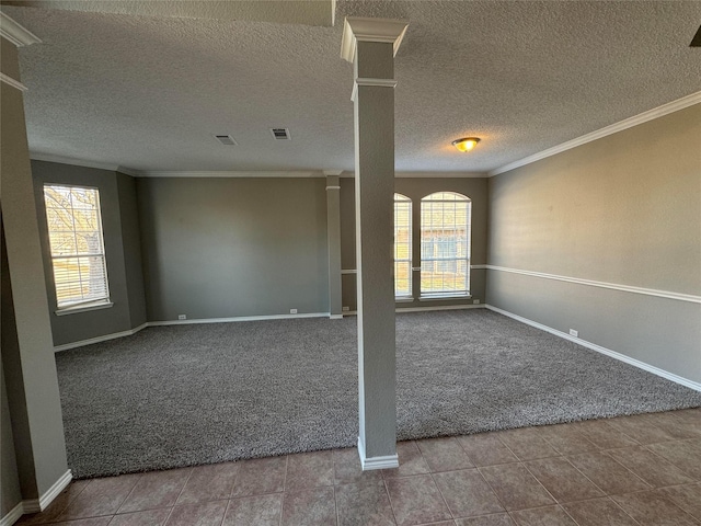 tiled empty room with ornamental molding and a textured ceiling