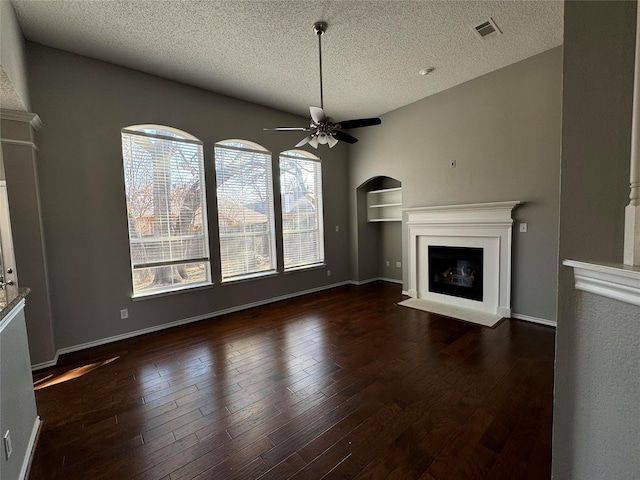 unfurnished living room with a textured ceiling, ceiling fan, and a wealth of natural light