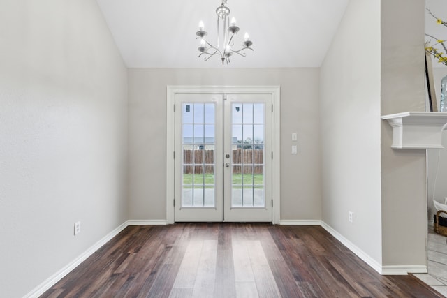 entryway featuring french doors, a notable chandelier, vaulted ceiling, and dark hardwood / wood-style floors