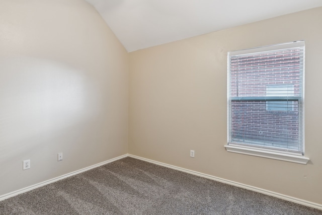 carpeted empty room with vaulted ceiling