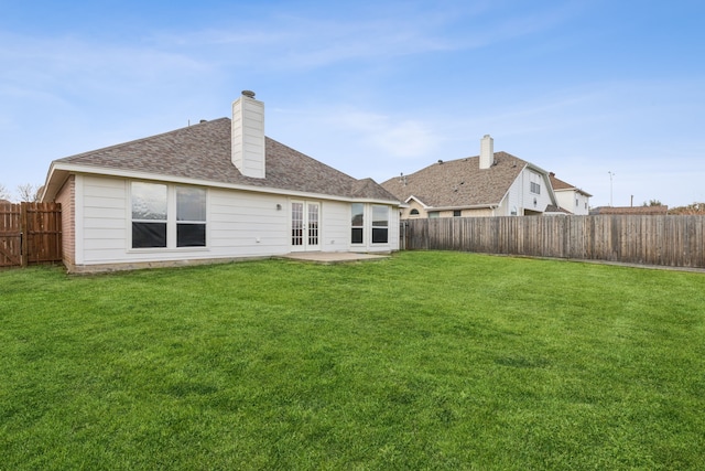 rear view of property with french doors and a lawn