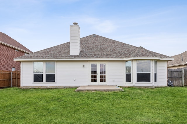 rear view of house with french doors and a lawn