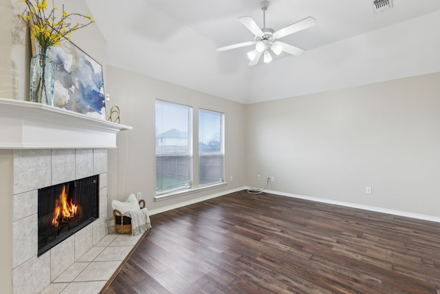 unfurnished living room featuring ceiling fan, hardwood / wood-style floors, vaulted ceiling, and a fireplace