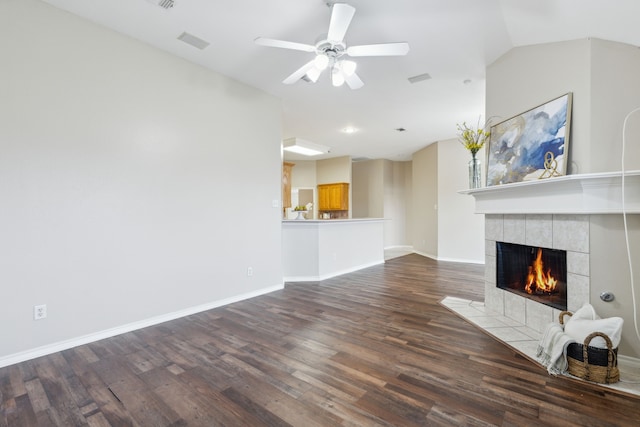 unfurnished living room with vaulted ceiling, ceiling fan, a fireplace, and hardwood / wood-style flooring