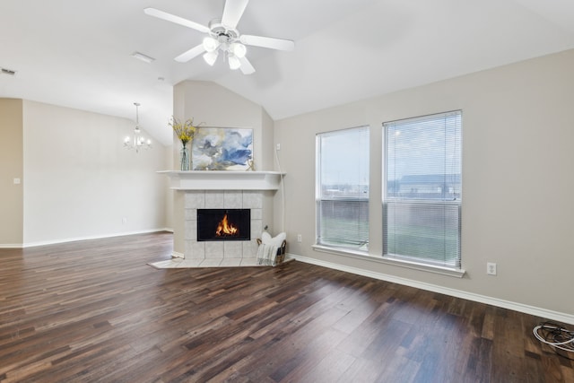 unfurnished living room featuring hardwood / wood-style flooring, plenty of natural light, a tiled fireplace, and vaulted ceiling