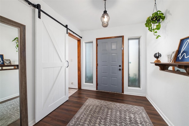 foyer featuring dark wood-type flooring and a barn door