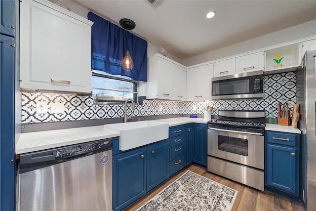 kitchen with stainless steel appliances, dark hardwood / wood-style floors, white cabinets, blue cabinets, and sink