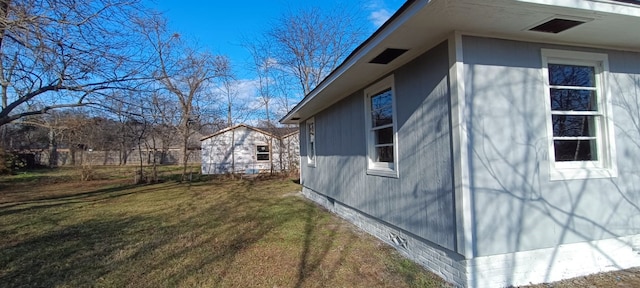 view of home's exterior featuring a lawn and an outbuilding