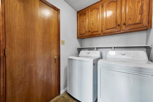 washroom with cabinets, separate washer and dryer, and a textured ceiling