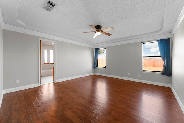 spare room featuring ceiling fan, ornamental molding, wood-type flooring, and a tray ceiling