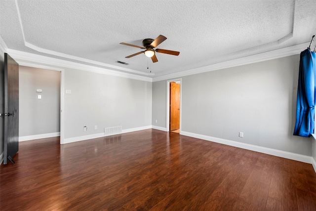 spare room featuring ceiling fan, dark wood-type flooring, a textured ceiling, and a raised ceiling