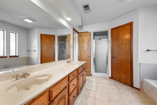 bathroom with vanity, tile patterned floors, plus walk in shower, and a textured ceiling