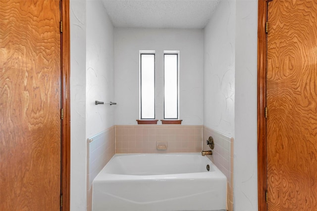 bathroom featuring a bath and a textured ceiling