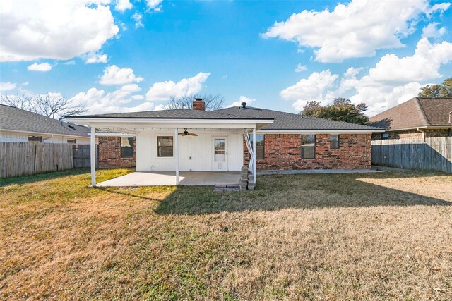 rear view of house featuring ceiling fan, a yard, and a patio