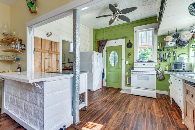 kitchen featuring white appliances, a kitchen breakfast bar, wood walls, tile counters, and dark hardwood / wood-style flooring