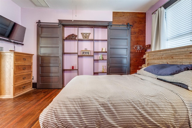 bedroom featuring wood walls and dark hardwood / wood-style floors