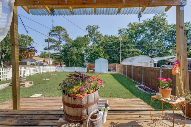 wooden deck with a lawn and a storage unit