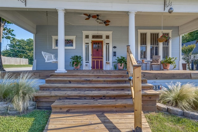 view of exterior entry featuring a porch and ceiling fan