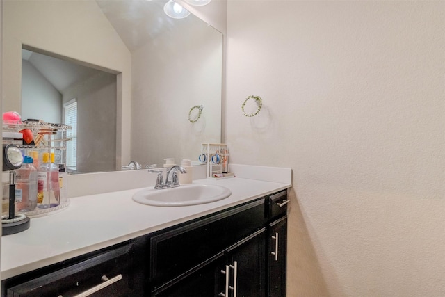 bathroom with vanity and vaulted ceiling