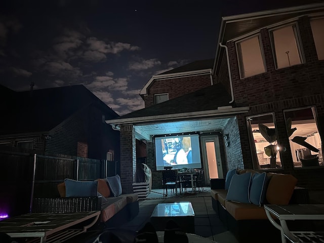 back house at night featuring an outdoor hangout area and a patio area