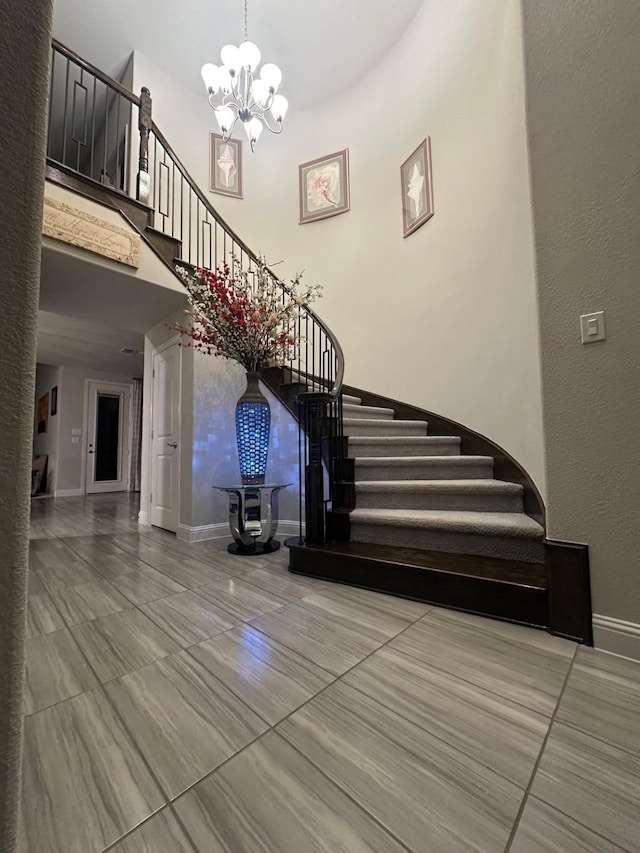 staircase featuring a towering ceiling and a notable chandelier