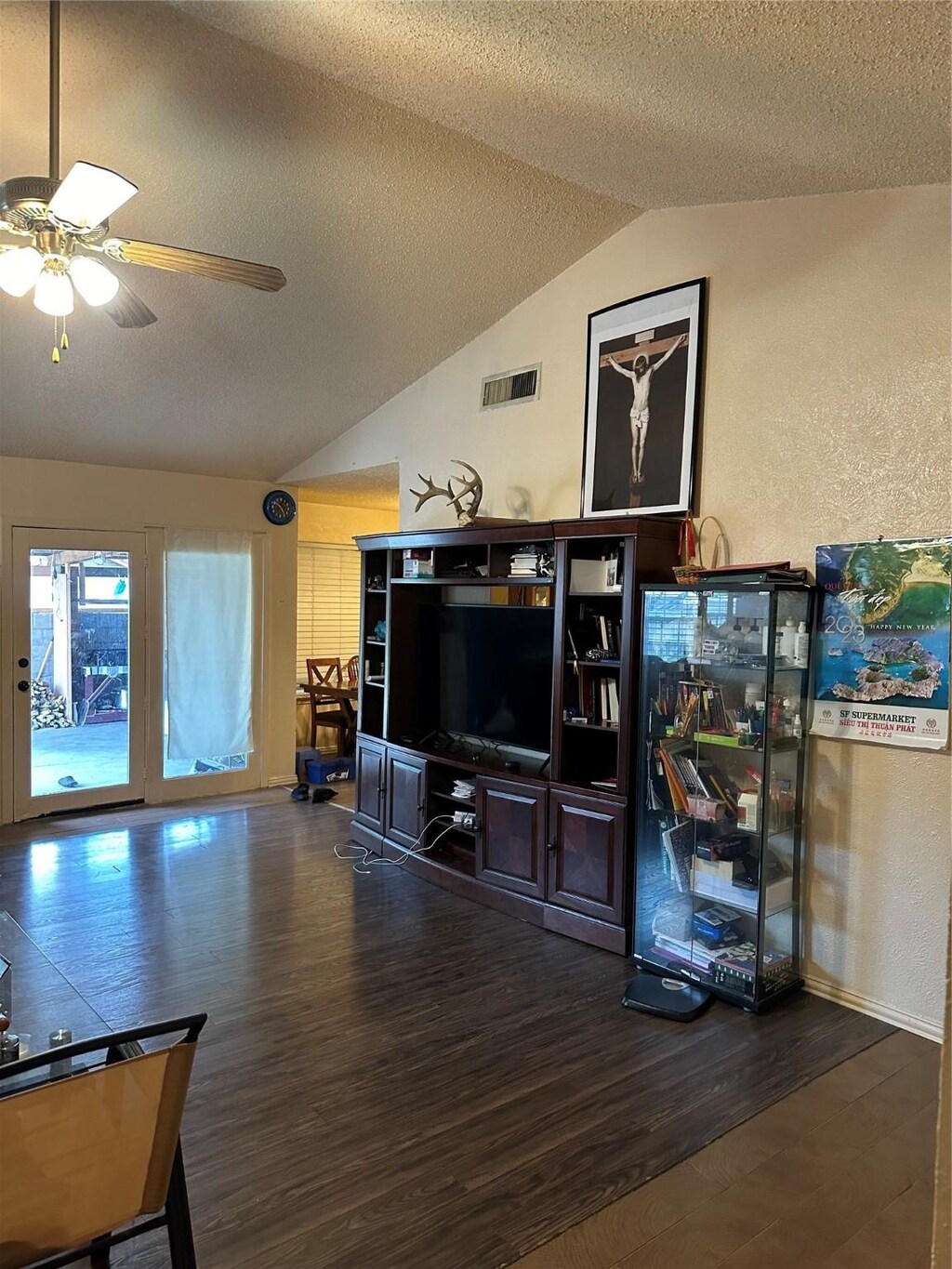 living room with lofted ceiling, a textured ceiling, ceiling fan, and dark hardwood / wood-style floors