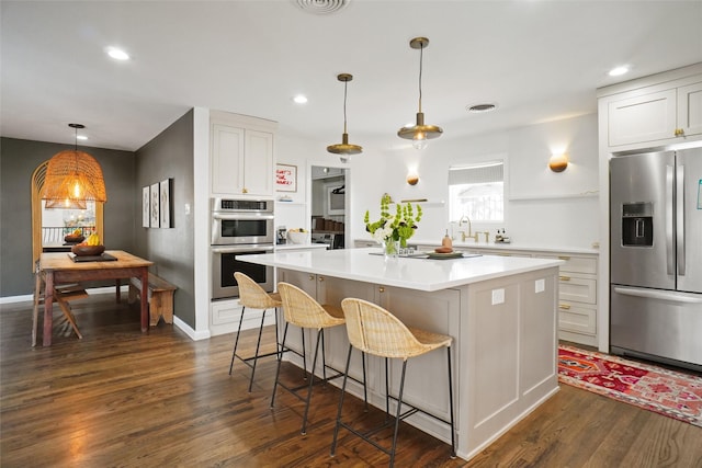 kitchen with stainless steel appliances, white cabinets, and a center island