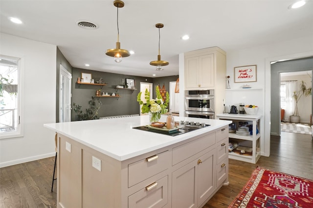 kitchen with pendant lighting, a center island, a wealth of natural light, stainless steel double oven, and dark hardwood / wood-style flooring