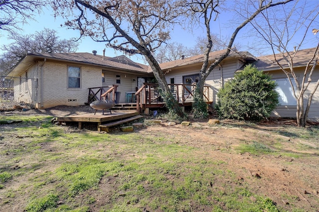 back of property featuring a deck and a lawn