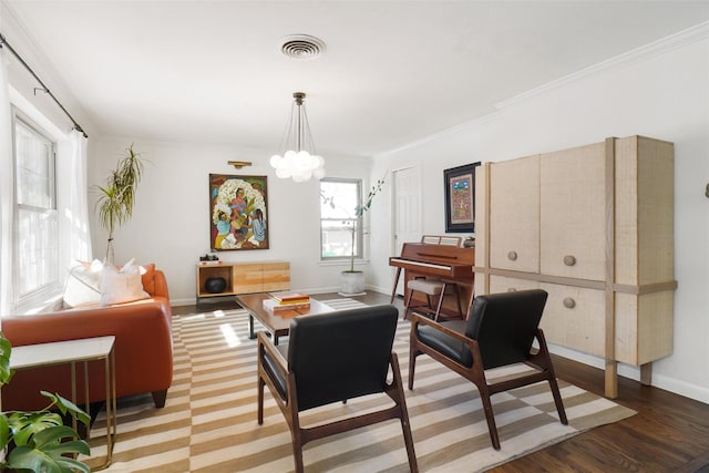 sitting room featuring wood-type flooring, ornamental molding, and an inviting chandelier