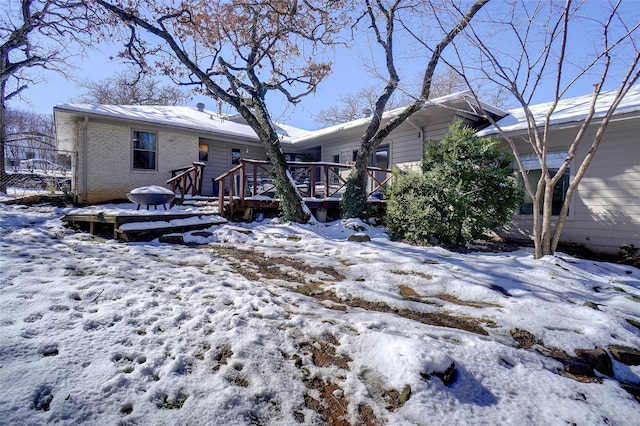 snow covered property featuring a wooden deck