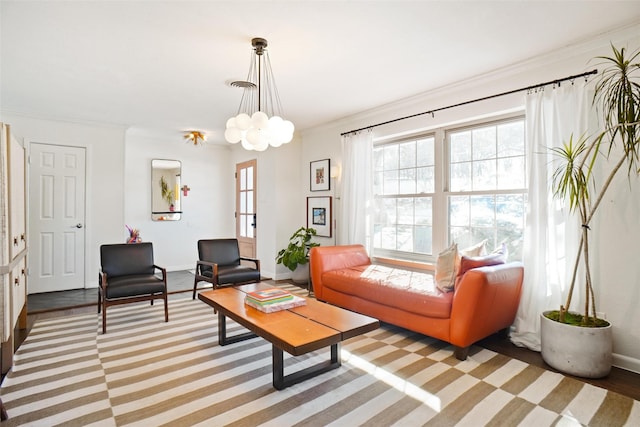 living room with crown molding, light wood-type flooring, and a notable chandelier