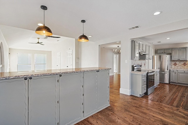 kitchen with stainless steel appliances, backsplash, dark hardwood / wood-style flooring, gray cabinetry, and ceiling fan with notable chandelier