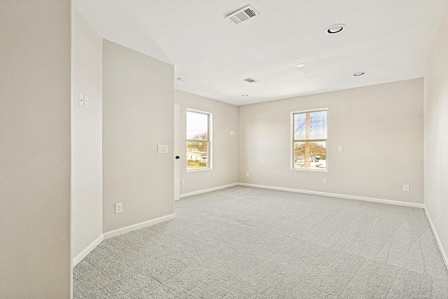 carpeted empty room with a textured ceiling