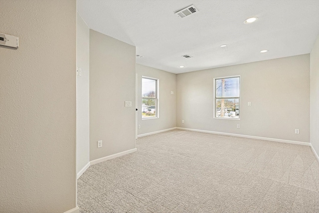 carpeted spare room featuring plenty of natural light