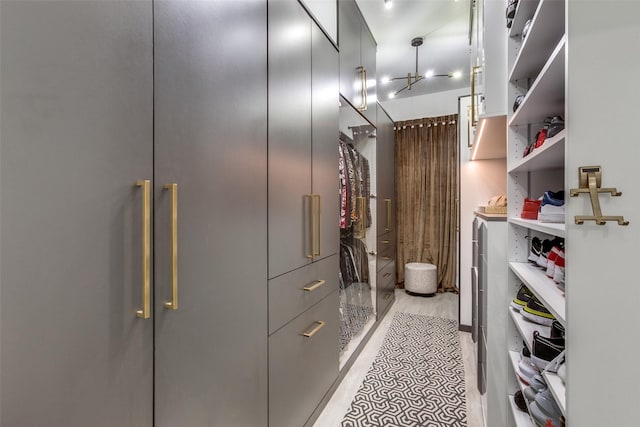 walk in closet featuring a chandelier