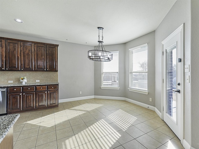 unfurnished dining area featuring an inviting chandelier and light tile patterned floors