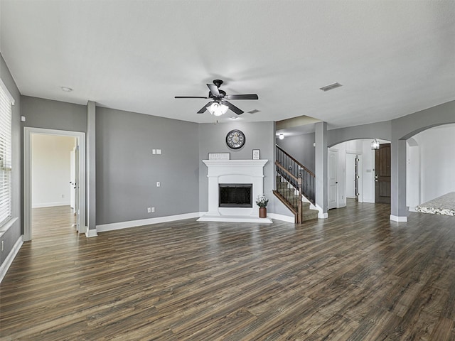 unfurnished living room featuring ceiling fan and dark wood-type flooring