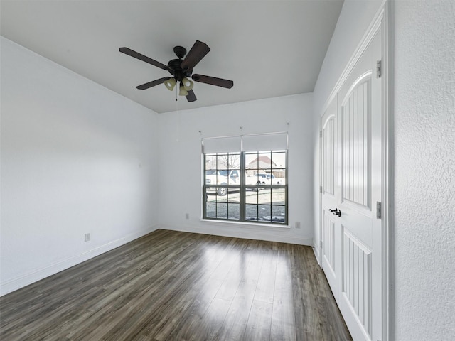 spare room featuring ceiling fan and dark hardwood / wood-style floors