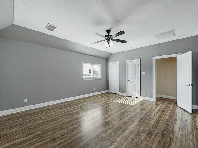 unfurnished bedroom featuring lofted ceiling, a textured ceiling, ceiling fan, and dark hardwood / wood-style flooring