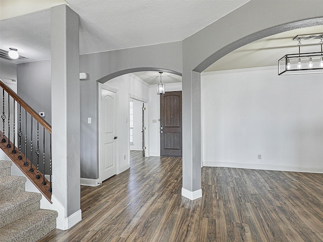 interior space featuring a textured ceiling and dark wood-type flooring