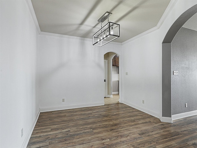 spare room with dark wood-type flooring and crown molding