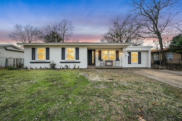 ranch-style house with a lawn and covered porch