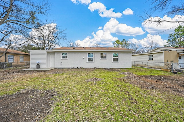 back of house with a patio area and a lawn