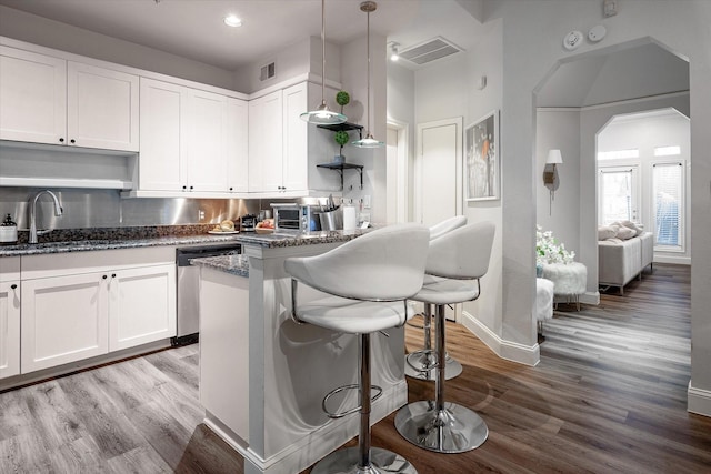 kitchen featuring white cabinets, stainless steel dishwasher, pendant lighting, and sink