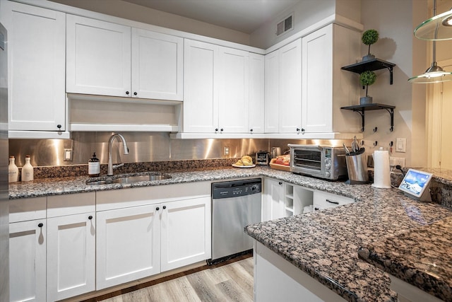 kitchen with dishwasher, hanging light fixtures, backsplash, white cabinetry, and sink