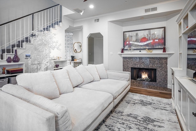 living room with a fireplace, crown molding, and hardwood / wood-style floors